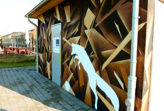 Graffiti-Projekt mit Spraydosen wurde ein Fuchs in Gelb- und Brauntönen an die Fassade einer WC-Anlage gesprüht