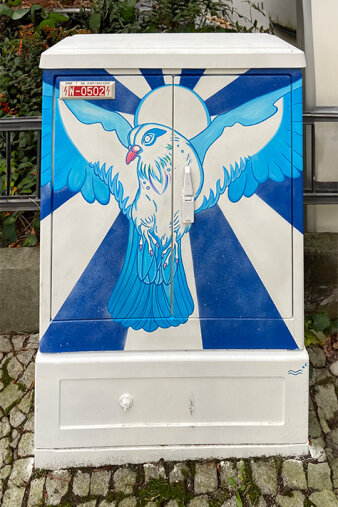 Graffiti-Projekt Medienkasten gestaltet mit einer blauen Taube vor einer Sonne.