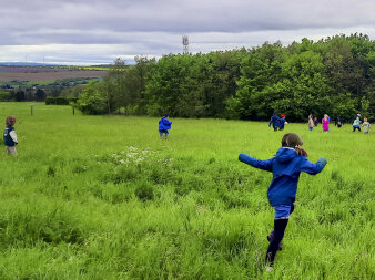 Kinder laufen und spielen auf einer grünen Wiese