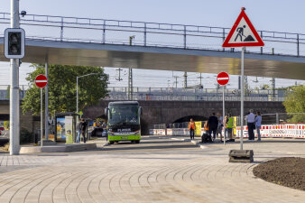 Ein Bus steht unter einer Brücke