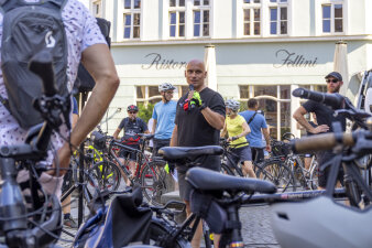 Ein Mann mit Mikrofon zwischen Fahrrädern