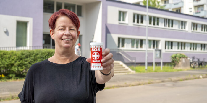 Eine Frau hält eine rote Dose in der Hand