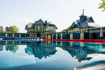 Ein mordernes Schwimmbecken, umgeben von historischen Bauten