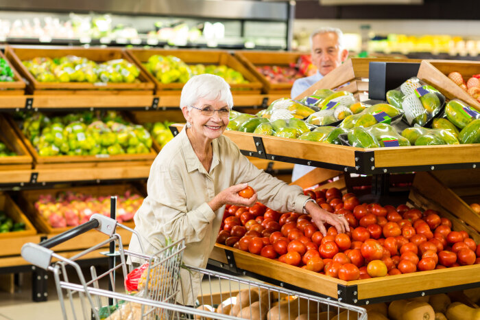 Ältere Dame am Tomatenstand im Supermarkt Ältere Dame am Tomatenstand im Supermarkt