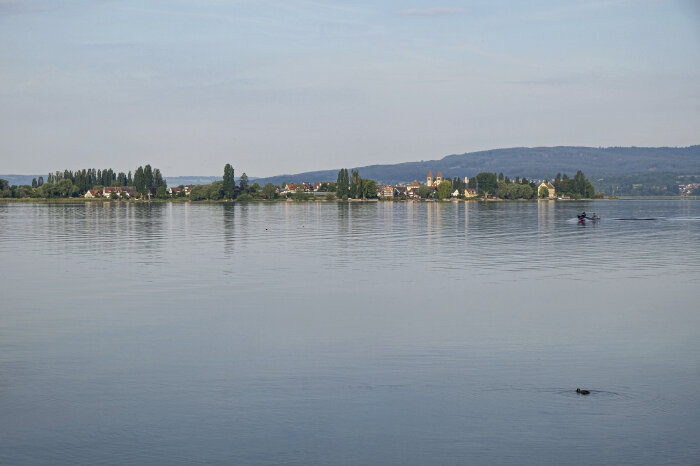 Eine Insel mit Bäumen und Gebäuden inmitten einer Wasserfläche 