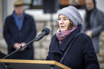 Frau mit Mütze und Brille die eine Rede hält